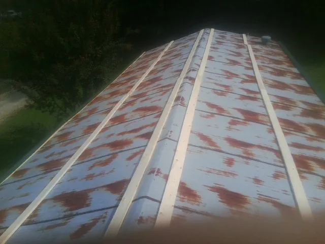 Rusted metal roof panels with new wood purlins before replacement — Storm Damage Roof Repair in East Saint Louis by Roofing Brothers